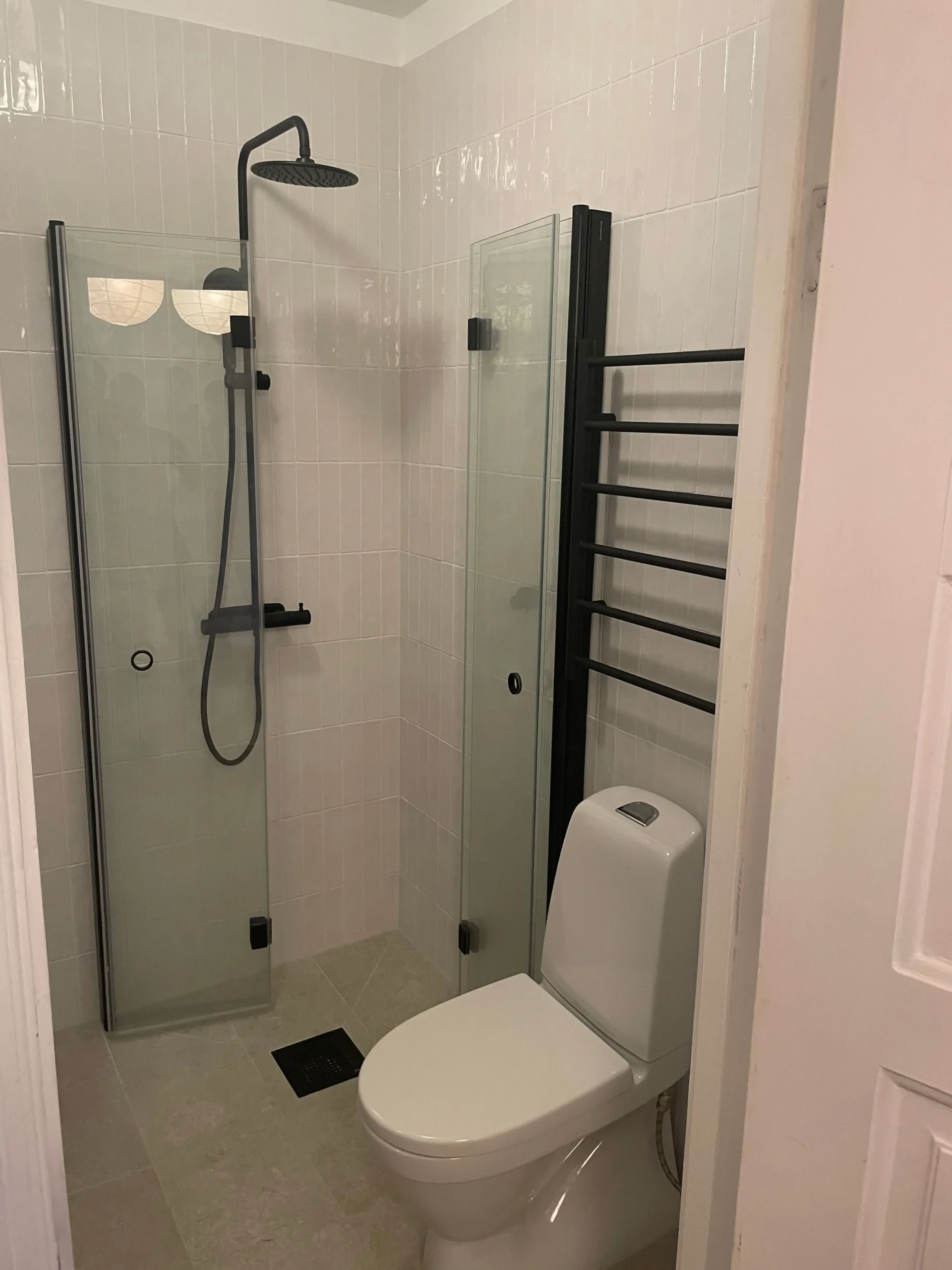 Modernt badrum efter renovering med stilren dusch